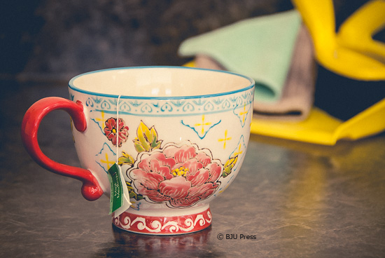 tea cup with tea bag and dustpan in the background