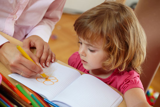 Closeup of cute little girl coloring drawing with mother 10415184