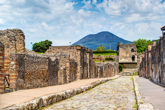 Street in Pompeii overlooking the Vesuvius. Pompeii is an ancient Roman city died from the eruption of Mount Vesuvius in 79 AD.