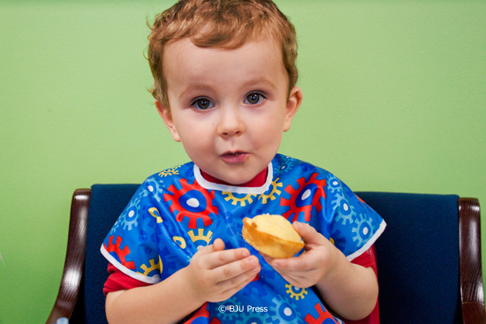 Image of a little boy eating corn bread.