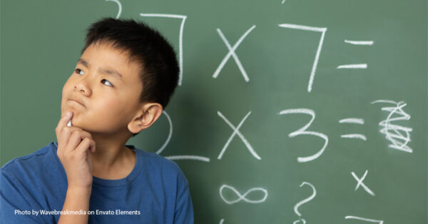 boy in front of chalk board thinking about math problems