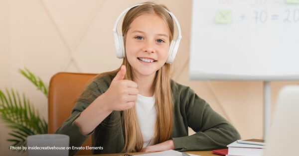 girl with headphones on giving a thumbs up sign