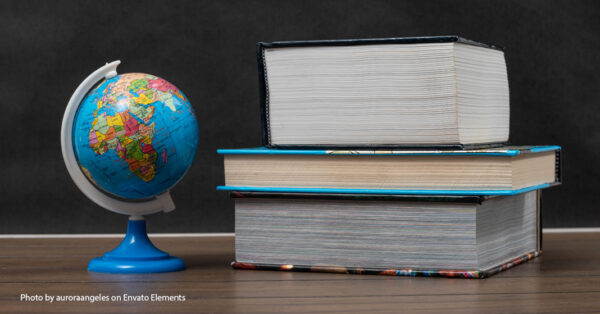 world globe sitting next to stack of books