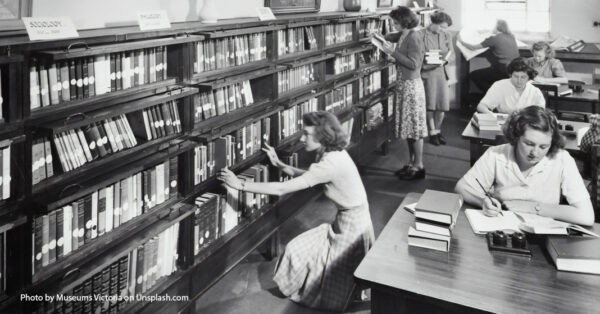 black and white photo of women in a library